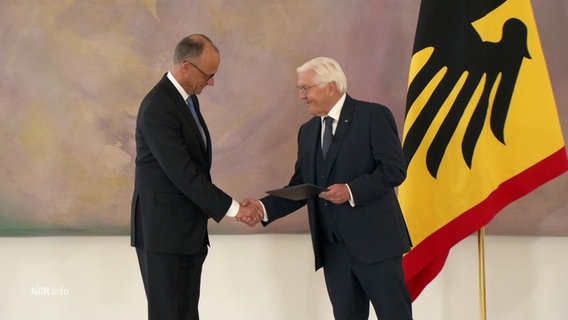 Bundespräsident Steinmeier überreicht Bundeskanzler Merz die Ernennungsurkunde und gratuliert ihm. © Screenshot 