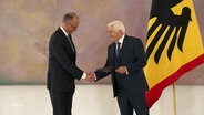 Bundespräsident Steinmeier überreicht Bundeskanzler Merz die Ernennungsurkunde und gratuliert ihm. © Screenshot 