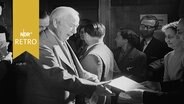 Theodor Heuss nimmt Stimmzettel zur Bundestagswahl 1953 in einem Wahllokal entgegen. © Screenshot 