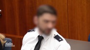 Der angeklagte Polizeibeamte vor Gericht. Sein Gesicht ist unkenntlich gemacht. © Screenshot 
