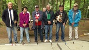 Mehrere Seniorinnen und Senioren stehen neben einer Minigolfbahn. © Screenshot 