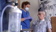 Eine Krankenschwester steht am Klinikbett eines Atemwegserkrankten, der an mehrere Maschinen angeschlossen ist. © Screenshot 