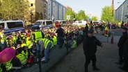 Demonstrierende sitzen auf einer Straße. © Screenshot 