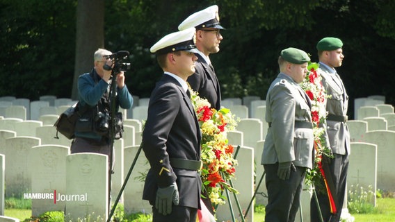 Mehrere Soldaten stehen mit Blumenkränzen auf dem Ohlsdorfer Friedhof. © Screenshot 