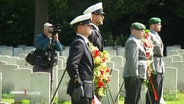 Mehrere Soldaten stehen mit Blumenkränzen auf dem Ohlsdorfer Friedhof. © Screenshot 