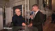 Reporter Phillip Kamke interviewt einen der Initiatoren der Gedenkveranstaltung in der Lübecker Marienkirche. © Screenshot 
