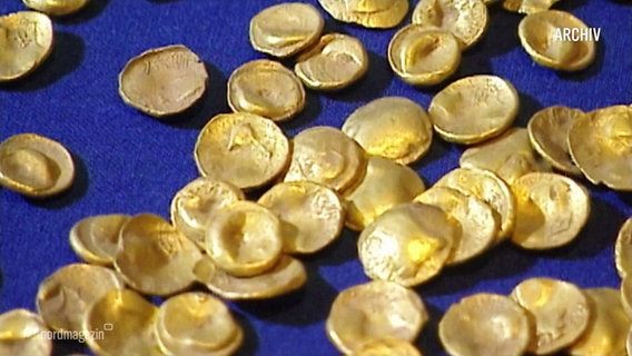 Goldmünzen liegen auf einem Tisch. © Screenshot 