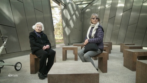 Zeitzeugin Irene Butter sitzt mit ihrer Tochter in einem Holocaust-Mahnmahl der KZ-Gedenkstätte Bergen-Belsen. © Screenshot 