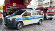 Ein Einsatzfahrzeug der Polizei steht vor den Treppen des Eingangs zum S-Bahnhof Hammerbrook. © TVNK 