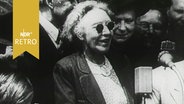 SPD-Politikerin Louise Schroeder, mit Sonnenbrille, umringt von Menschen, in den 1950er Jahren bei einer Rede. © Screenshot 