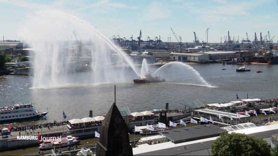 Ein Blick auf die Elbe mit mehreren Schiffen, eines davon spritz Wasserfontänen in unterschiedliche Richtungen. © Screenshot 