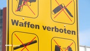Ein Schild mit Aufschrift: "Waffen verboten". © Screenshot 