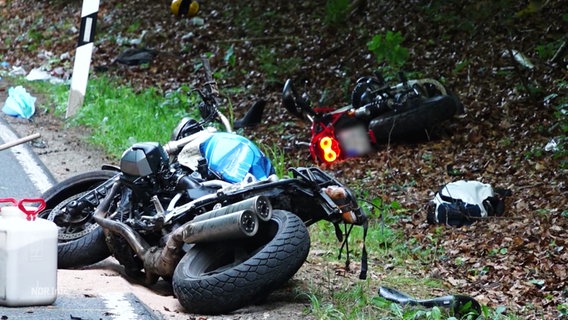 Zwei verunglückte Motorräder liegen am Straßenrand. © Screenshot 