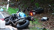 Zwei verunglückte Motorräder liegen am Straßenrand. © Screenshot 