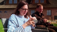 Eine Frau und ein Mann essen ein Eis im Garten. © Screenshot 