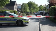 Ein Polizeiwagen steht auf der Straße hinter einem Absperrband. © Screenshot 