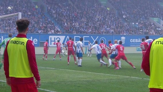 Fußballer von Hansa Rostock und Energie Cottbus spielen auf dem Feld. © Screenshot 