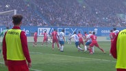 Fußballer von Hansa Rostock und Energie Cottbus spielen auf dem Feld. © Screenshot 