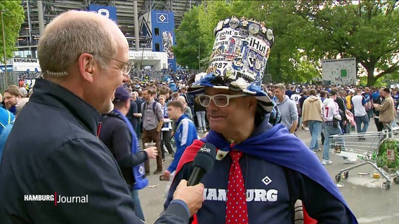 Reporter Thorsten Vorbau  im Gespräch mit einem HSV-Fan. © Screenshot 