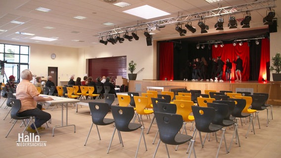 Eine Theatergruppe steht bei einer Probe auf der Bühne. © Screenshot 