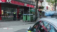 Polizisten stehen vor einem Restaurant. © Screenshot 