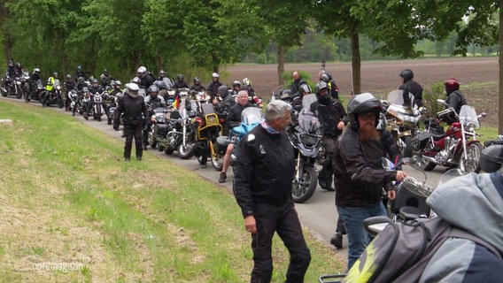 Viele Biker und Motorräder stehen auf einer Straße. © Screenshot 