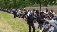 Viele Biker und Motorräder stehen auf einer Straße. © Screenshot 