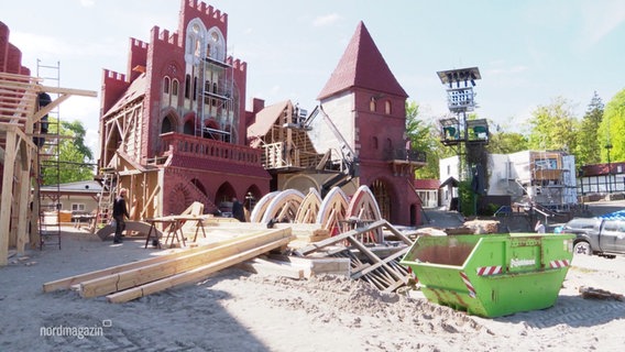Auf einer Freilicht-Festspielbühne sind meterhohe Kulissen von hanseatischen Kontorshäusern aufgebaut. © Screenshot 