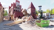 Auf einer Freilicht-Festspielbühne sind meterhohe Kulissen von hanseatischen Kontorshäusern aufgebaut. © Screenshot 