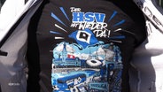 Auf einem T-Shirt steht: „Der HSV ist wieder da!“ © Screenshot 