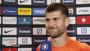 Ben Voller, Torhüter beim FC St. Pauli, lächelnd vor dem Mikrofon. © Screenshot 