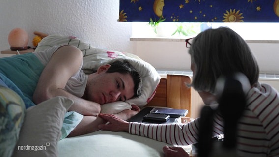 Ein junger Mann liegt in einem Bett. © Screenshot 
