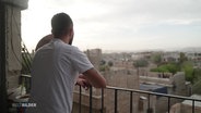 Ein junger Syrer blickt von einem Balkon auf die Stadt. © Screenshot 