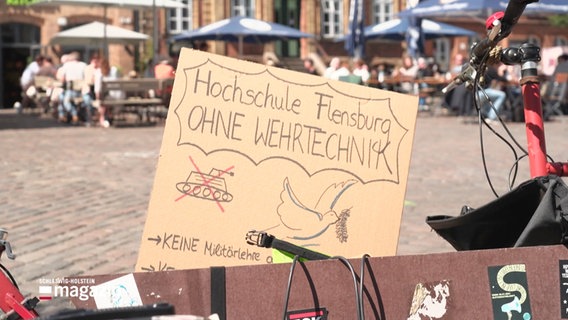 Ein Protestschild gegen Wehrtechnik an der Hochschule Flensburg. © Screenshot 