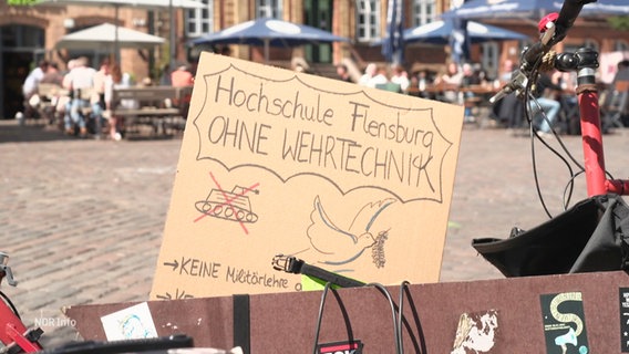 Ein Protestschild gegen Wehrtechnik an der Hochschule Flensburg. © Screenshot 