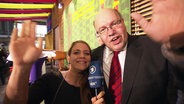 Jasmin Al-Safi und Bundesumweltminister Peter Altmaier winken in die Kamera.  