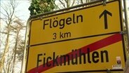 Ein Ortschild mit der Aufschrift "Fickmühlen"  