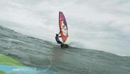 Ein Surfer in der Nordsee bei Sylt.  