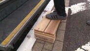 Ein Treppchen aus Holz soll Menschen in den Zug helfen.  