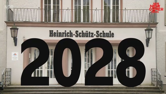Vor einem Gebäude mit der Aufschrift "Heinrich-Schütz-Schule" steht die große Zahl 2028.  