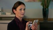Eine Frau hält ein Handy in der Hand. © NDR 