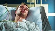 Nils Schiller (Max Woelky) liegt verkabelt in einem Krankenhausbett. © Screenshot 