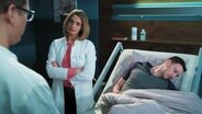 Ärztin, die am Patientenbett steht.  