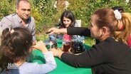 Familie Yossef sitzt im Kleingarten und trinkt Tee.  