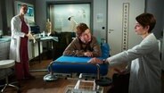Katharina Nesytowa und Mirka Pigulla behandeln Leon Seidel in einer Szene von "In aller Freundschaft - Die jungen Ärzte". © screenshot 