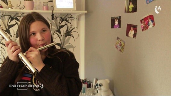 Tochter, die auf der Flöte spielt.  