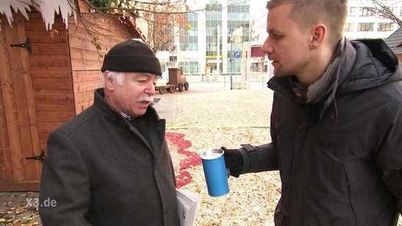 Tobias Schlegl, mit Spendendose, redet mir einem älteren Herren  