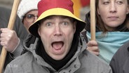 Ein Mann, mit aufgerissenem Mund, trägt einen Deutschland-Hut  