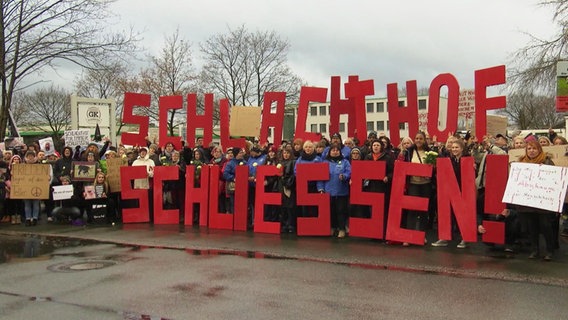 Demonstranten in Oldenburg halten Buchstaben hoch, die die Worte "Schlachthof schließen!" ergeben.  