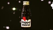 Auf dem Etikett einer kleinen Flasche steht "Doppelmoral".  